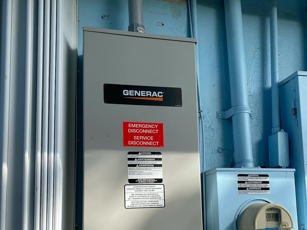 Generac automatic transfer switch mounted beside the electric meter on a home