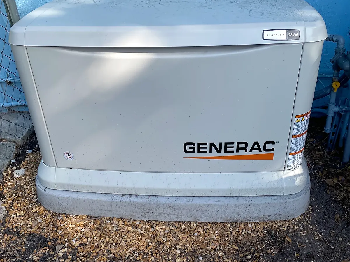 Generac Guardian home standby generator on a pad beside a house