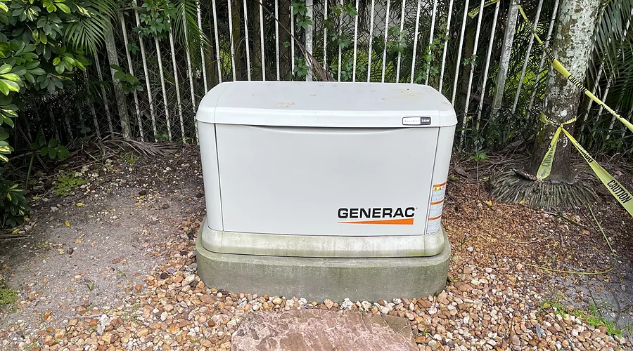 Generac home standby generator on a concrete pad in a fenced side yard