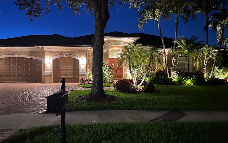 Landscape lighting and palm tree uplights on a South Florida home at night