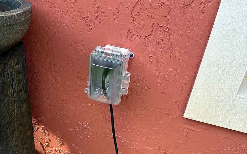 Outdoor outlet with a weatherproof in-use cover on a stucco wall