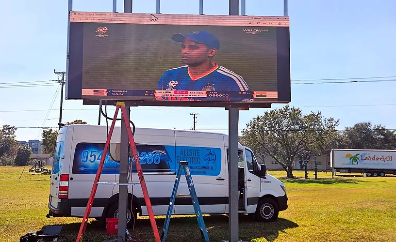 Allsite Electric van under an outdoor video board at a sports park